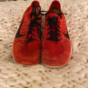 Men’s red and orange Nike tennis shoes